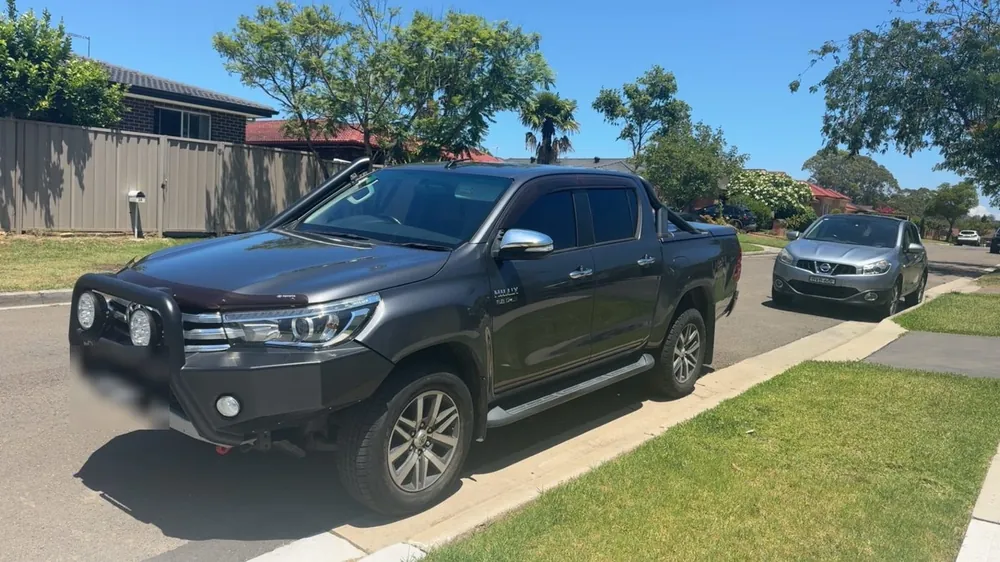 Toyota Hilux SR5 with bull bar and driving lights in a driveway