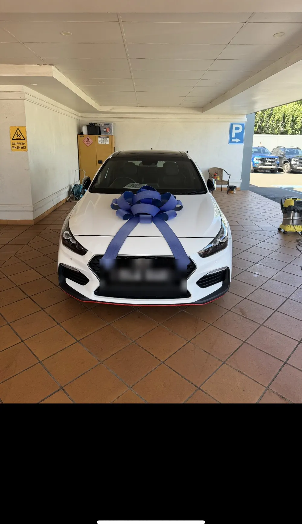 White Hyundai i30 N on delivery day with a blue bow on the bonnet